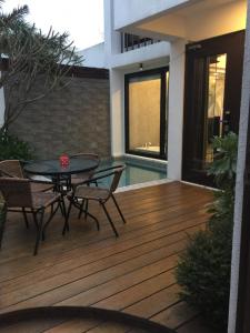 un patio con tavolo e sedie su un ponte di legno di Mou Xia Villa a Wujie