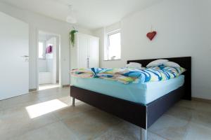 バート・クロツィンゲンにあるFerienwohnungen Herzleのベッドルーム1室(青い掛け布団付きのベッド1台付)