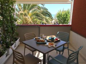 a table and chairs on a balcony with food on it at SulMare Alba Adriatica in Alba Adriatica