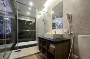 un bagno con lavandino e doccia in vetro di Mou Xia Villa a Wujie
