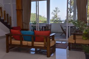a living room with red and blue cushioned chairs at Tea Hills Bungalow in Hatton