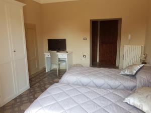 ein Schlafzimmer mit zwei Betten und einem Schreibtisch mit Computer in der Unterkunft Nonna Ninetta in Melfi