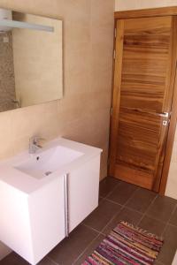 ein Badezimmer mit einem Waschbecken, einem Spiegel und einer Tür in der Unterkunft Panorama Mediterranea in St Paul's Bay