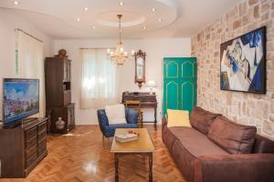 a living room with a couch and a tv at Apartments Laurus in Šibenik