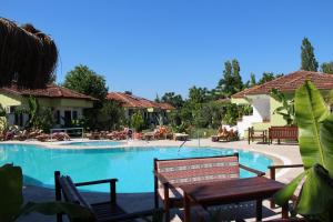 a pool at a resort with chairs and tables at Hotel Riverside in Dalyan