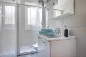 a white bathroom with a sink and a shower at Top Center Rooms & Studio in Pula