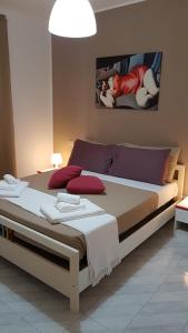 ジャルディーニ・ナクソスにあるLoft Baia Di Giardiniのベッドルーム1室(大型ベッド1台、赤い枕付)