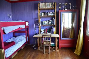 ロクテュディにあるGîtes La zélidjaの紫の壁のベッドルーム(テーブル、本棚付)