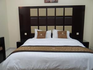 a bedroom with a large bed with a black headboard at Royal Home Furnished Apartments in Wadi Al Dawasir