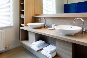 uma casa de banho com dois lavatórios num balcão com toalhas em Hotel Boomgaard em Lanaken