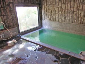 una gran piscina con una ventana en el baño en Hotel Route-Inn Suwa Inter, en Suwa