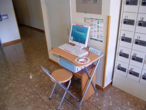
a laptop computer sitting on top of a wooden desk at Hotel Route-Inn Suwa Inter in Suwa
