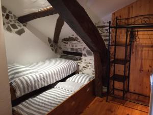 two beds in the corner of a room at Chambres d'Hôtes Auberg'inn in Ambialet