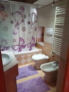 a bathroom with two toilets and a shower curtain at B&B Casa dei Lillà in Santeramo in Colle