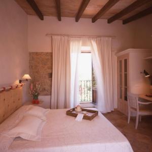 a bedroom with a large bed and a window at Agroturismo Na Set Centes - Adults Only in Artá