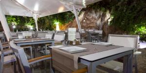 a restaurant with tables and chairs and vines at Hotel Casa Román in Sanxenxo