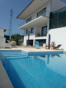 a house with a swimming pool in front of a house at Casa de Coelhosa in Vale de Cambra