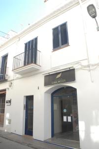 un edificio bianco con una porta e un cartello sopra di Apartaments Bonaventura 7 a Sitges