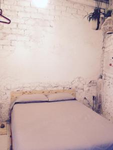 Bett in einem Zimmer mit einer weißen Ziegelwand in der Unterkunft Apartments San Ignacio de Loyola in Manresa