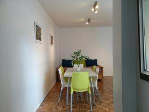 Un comedor con una mesa y sillas amarillas. en Apartamento Edificio Crucero, en Buenos Aires
