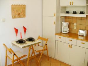 cocina pequeña con mesa, sillas y fogones en Castle Area Apartment, en Budapest