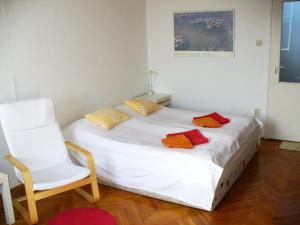 a bedroom with a white bed and a white chair at Castle Area Apartment in Budapest