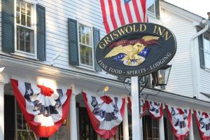 um sinal em frente a um restaurante com uma bandeira americana em The Griswold Inn em Essex