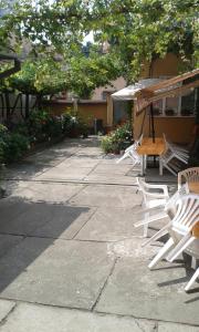 a group of white chairs and an umbrella at Pensiunea Damiris in Baile Felix