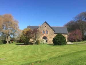 a large brick house with a green lawn at La Chambre Montbrault in Fleurigné