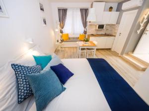 a large white bed with blue pillows in a room at Navis Luxury Apartments in Vodice