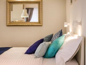 ein Schlafzimmer mit einem Bett mit Kissen und einem Spiegel in der Unterkunft Navis Luxury Apartments in Vodice