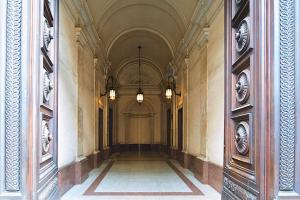 un couloir vide dans un bâtiment avec deux lumières dans l'établissement Vittoriano Luxury Suites, à Rome