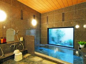 baño con bañera y TV de pantalla grande en Hotel Route-Inn Sagamihara -Kokudo 129 Gou-, en Sagamihara