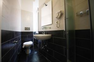 uma casa de banho com um lavatório, um WC e um espelho. em Hotel Pisa em Roma