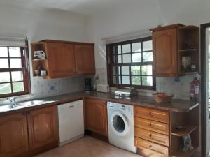 Una cocina con muebles de madera y lavadora. en Alsouk, en Vilamoura