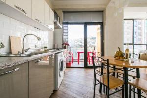 una cucina con tavolo, lavandino e piano di lavoro di 3 Bedroom 2 Bathroom Apartment on Saburtalo Gagarin a Tbilisi City