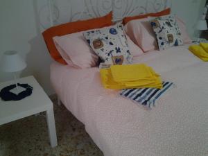 a bed with colorful pillows on it with a table at I Colori di Salvator Rosa in Naples