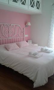 sypialnia z dużym białym łóżkiem i różowymi ścianami w obiekcie Exclusive Views Ronda w mieście Ronda