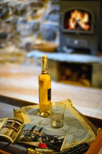 a bottle of oil on a table with a book and a glass at La Casa Antollosdocesar in Baralla +16 photos