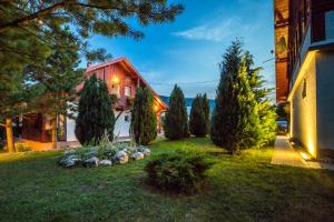 a house with a yard with trees and bushes at Boutique house Oreskovic in Plitvička Jezera