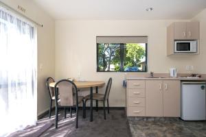 a kitchen with a table and chairs in a room at Ashleigh Court Motel in Blenheim