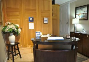 uma sala de espera com uma secretária e um vaso de flores em Motel des Cèdres em Sherbrooke