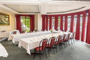 una sala de conferencias con mesas blancas y cortinas rojas en Barkly Motorlodge en Ballarat
