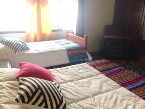 a room with two beds and a window at Quito Kawsay in Quito