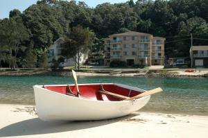 a white boat sitting on top of a sandy beach at Marcel Towers Holiday Apartments in Nambucca Heads
