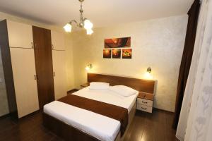 a bedroom with a large bed with white sheets at Apartament Erika - by the beach in Constanţa