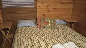 ein großes Bett in einem Zimmer mit 2 Tischen in der Unterkunft Turismo Montaña II in La Ensenada