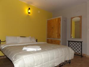 a bedroom with a white bed with a yellow wall at Silent Wild in Masinagudi