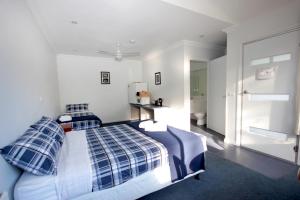 um quarto com uma cama com almofadas azuis e brancas em The Abbey Raymond Island em Raymond Island