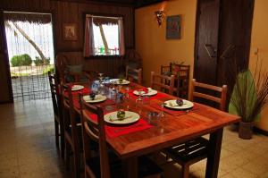 a wooden table with chairs and a dining room at Villas de Vohilava in Sainte Marie